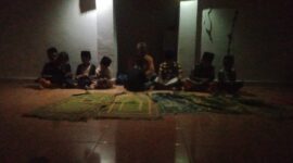Anak-anak mengikuti pembelajaran mengaji di Musholla An-Nuur dengan penerangan terbatas akibat gangguan listrik.